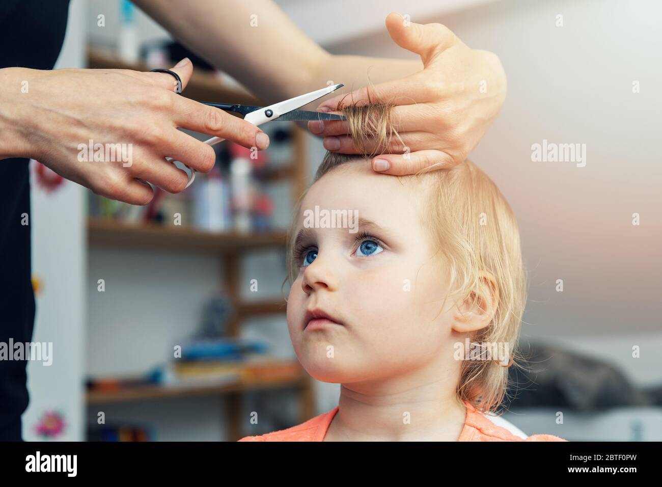 mother doing haircut for her child at home Stock Photo