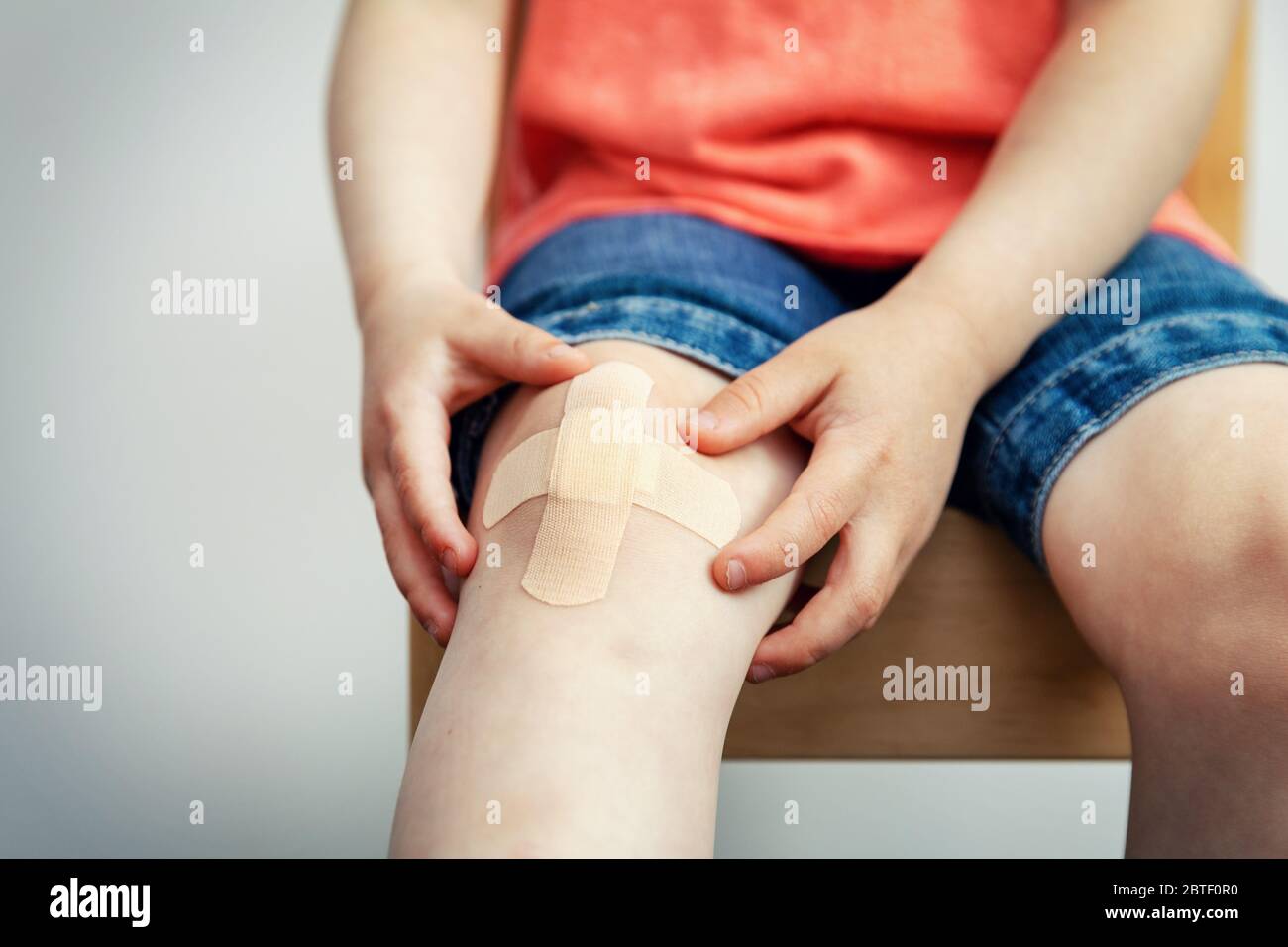 child knee with adhesive medical plaster strip bandage Stock Photo