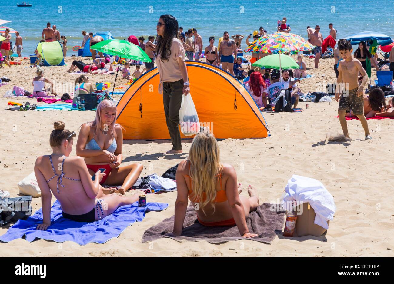 Bournemouth, Dorset UK. 25th May 2020. UK weather: scorching hot at Bournemouth beaches with clear blue skies and unbroken sunshine, as temperatures soar on Bank Holiday Monday. Sunseekers flock to the seaside and beaches are packed, with car parks full and cars left anywhere and everywhere. Credit: Carolyn Jenkins/Alamy Live News Stock Photo