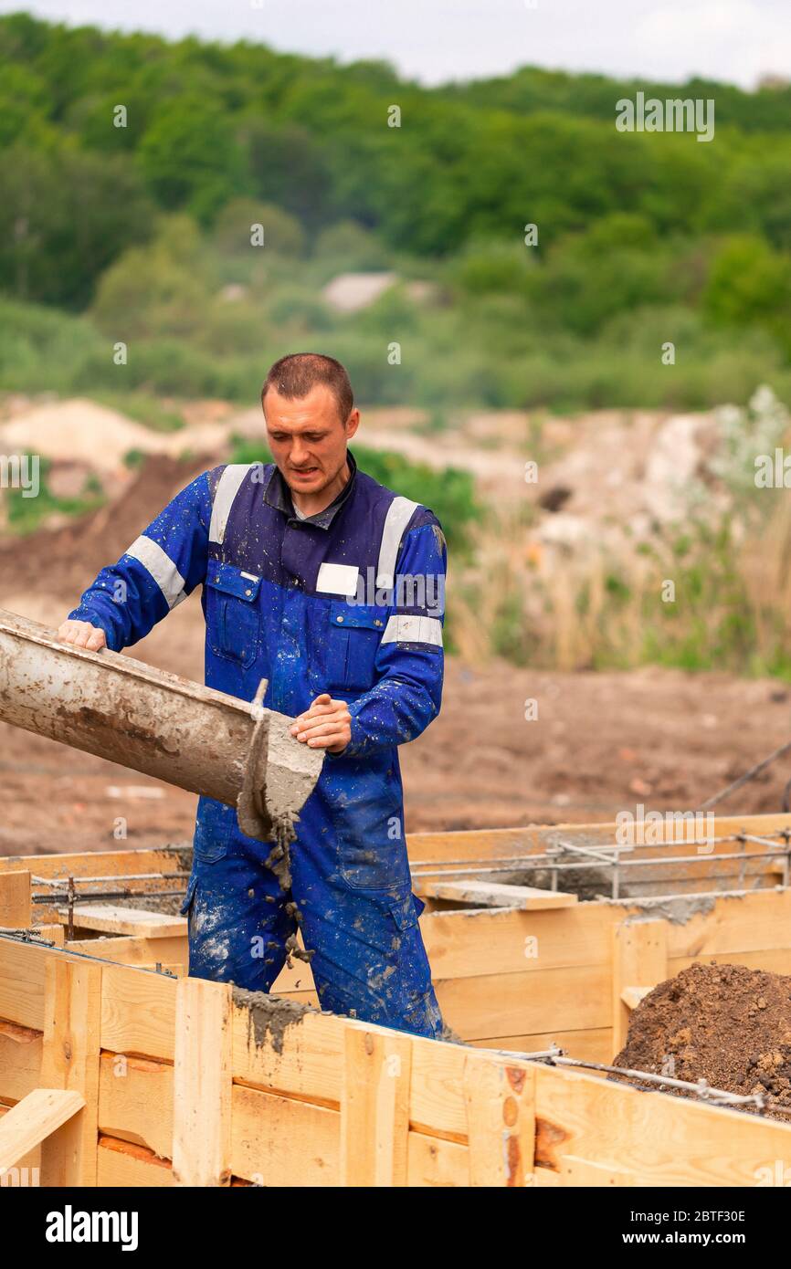 Construction worker laying cement or concrete into the foundation