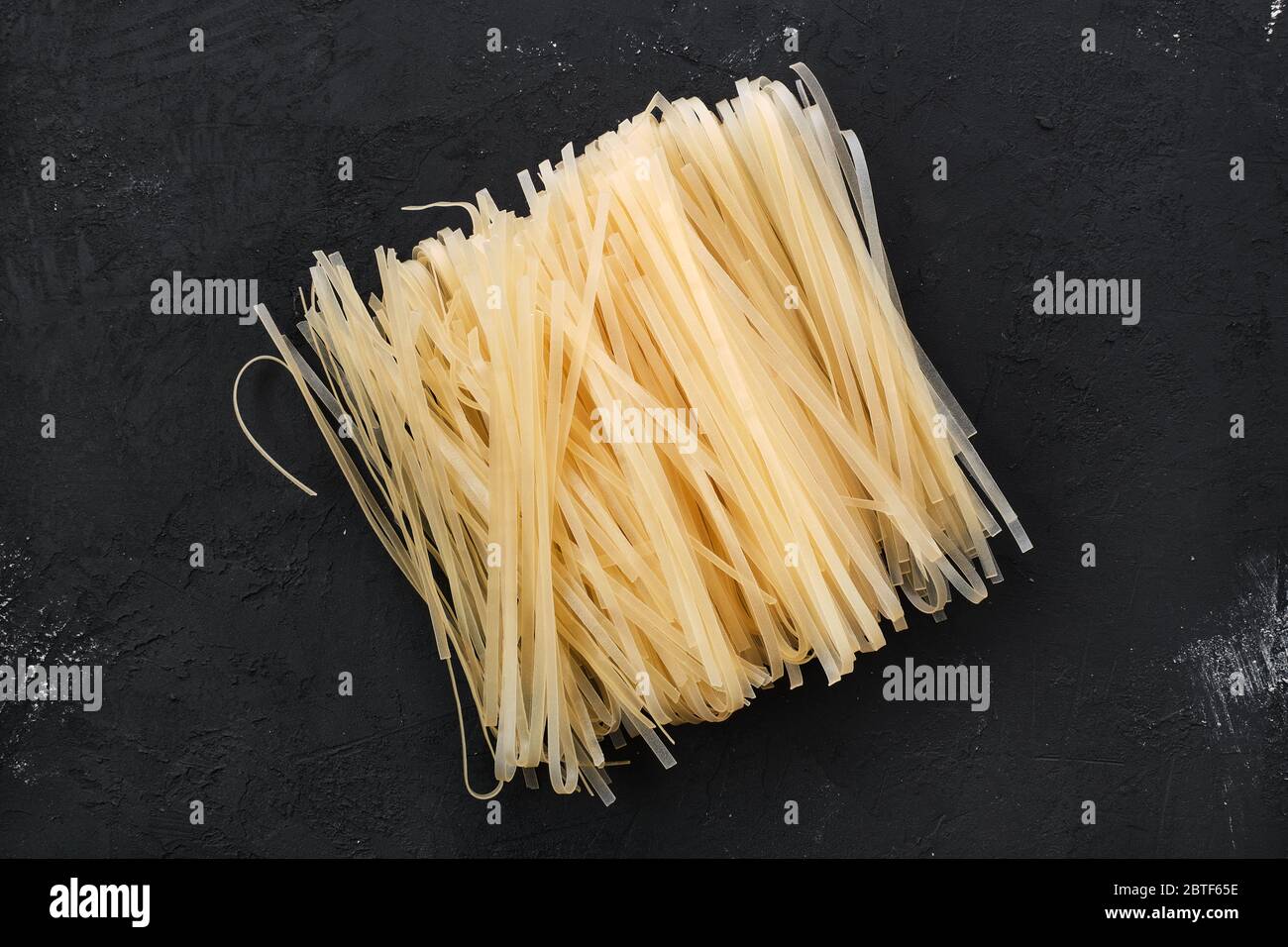 Dry rice stick noodles on black background Stock Photo Alamy