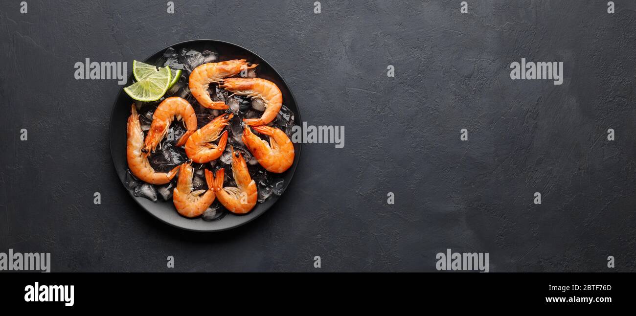 Fresh raw shrimp with ice on a black stone background. Seafood. Top ...