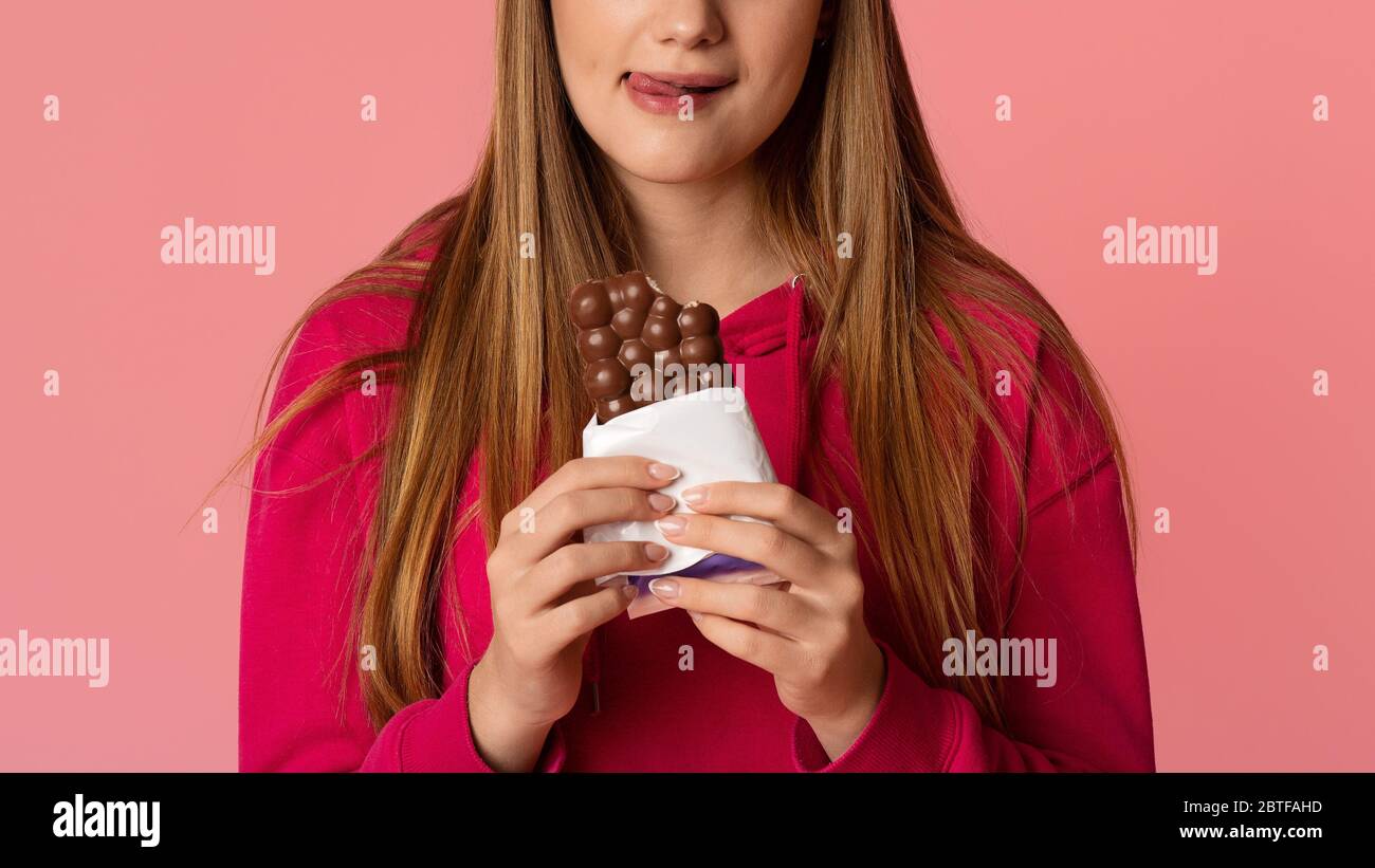 Sweet tooth concept. Girl licks her lips with tongue and holds