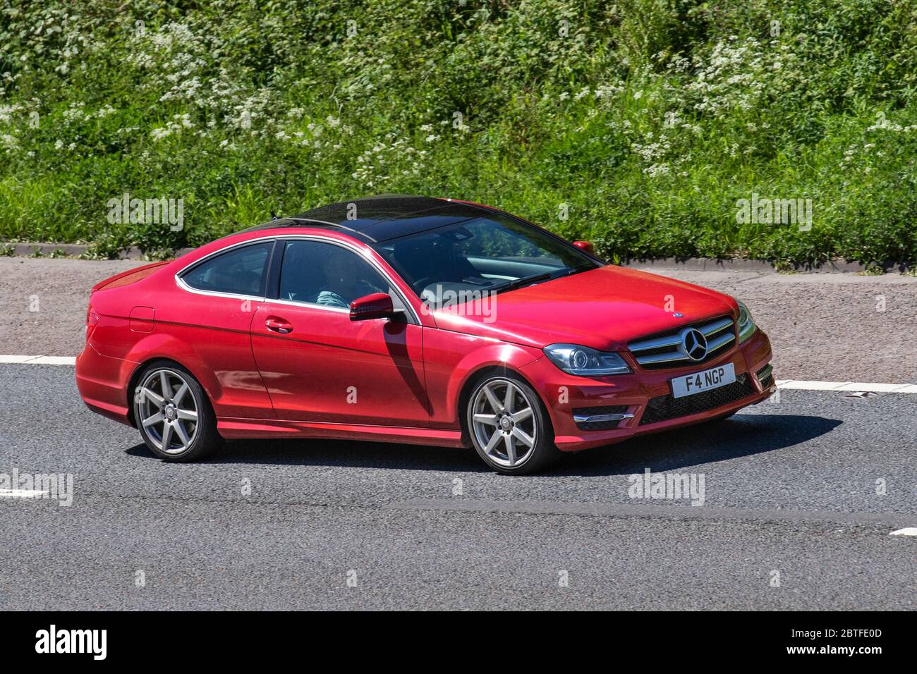 2014 red Mercedes-Benz C250 AMG Sport EDT Prem +; Mercedes-Benz C250 AMG Sport EDT Prem +; Vehicular traffic moving vehicles, cars driving vehicle on UK roads, motors, motoring on the M61 motorway highway in Manchester, UK Stock Photo