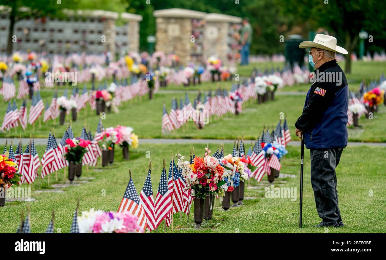 Bear, Delaware, USA. 25th May, 2020. A visitor walks among the grave stones and flags while paying respects on Memorial Day. While the Delaware VeteranÕs Memorial Cemetery did not hold their annual Memorial Day remembrance service, many showed up with masks and observing social distancing to pay respects and remember loved ones during the coronavirus pandemic. Scott Serio/ESW/CSM Credit: Cal Sport Media/Alamy Live News Stock Photo