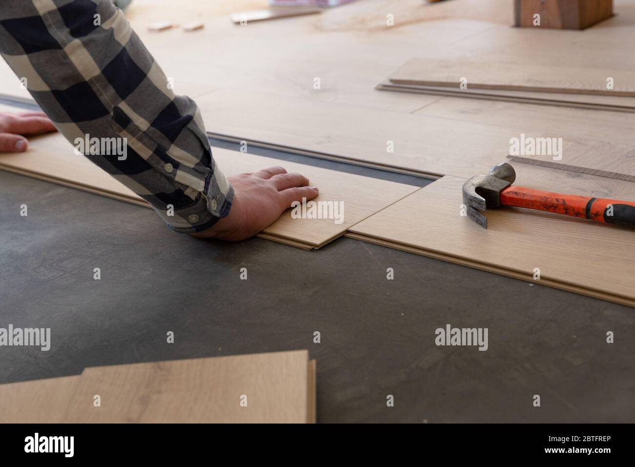 Construction worker installing laminate floor in a new renovated attic. Home improvement concept. Stock Photo