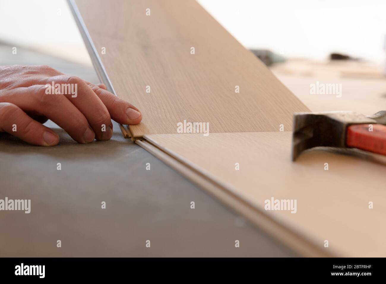 Construction worker installing laminate floor in a new renovated attic. Home improvement concept. Stock Photo