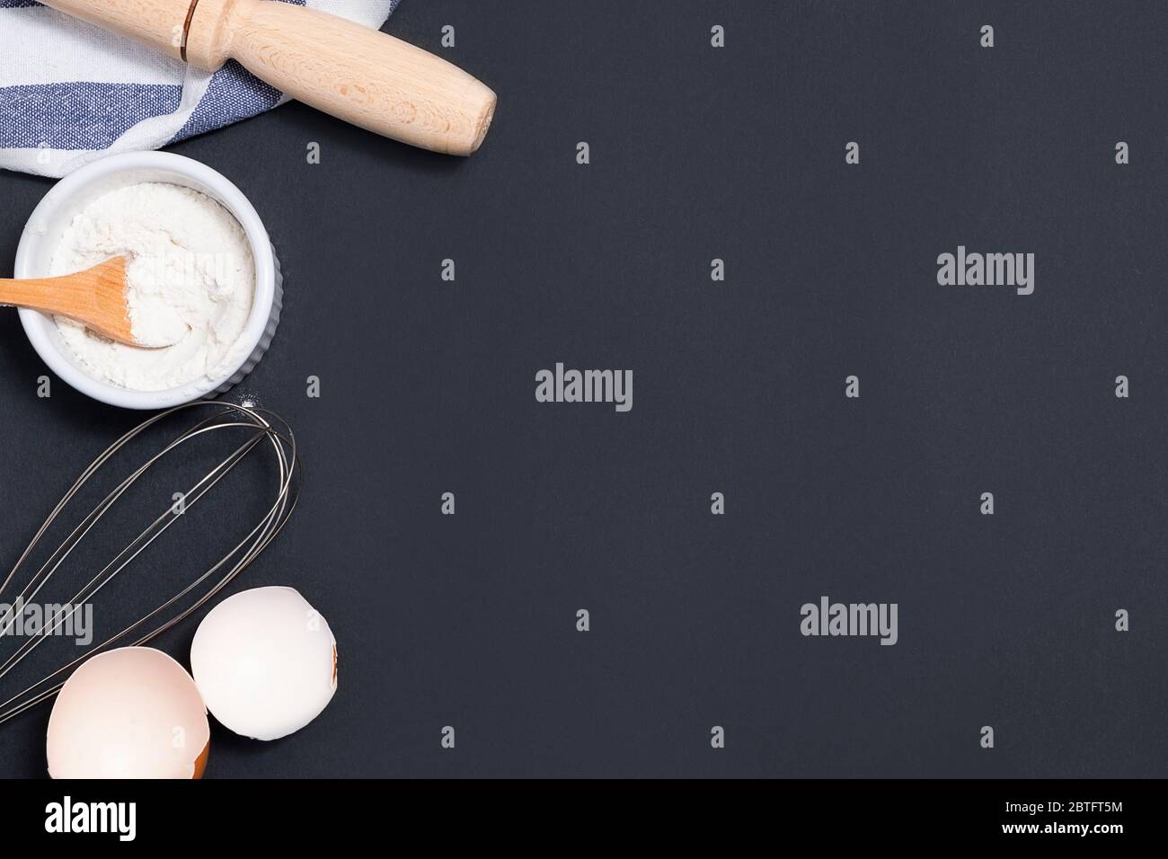 Top view of backing background with flour, rolling pin, eggshells, utility whisk with copy space Stock Photo
