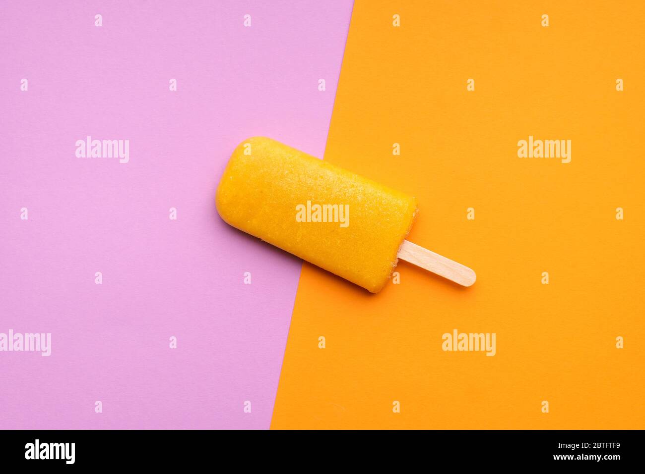 Orange flavored ice cream popsicle on a seamless colorful background