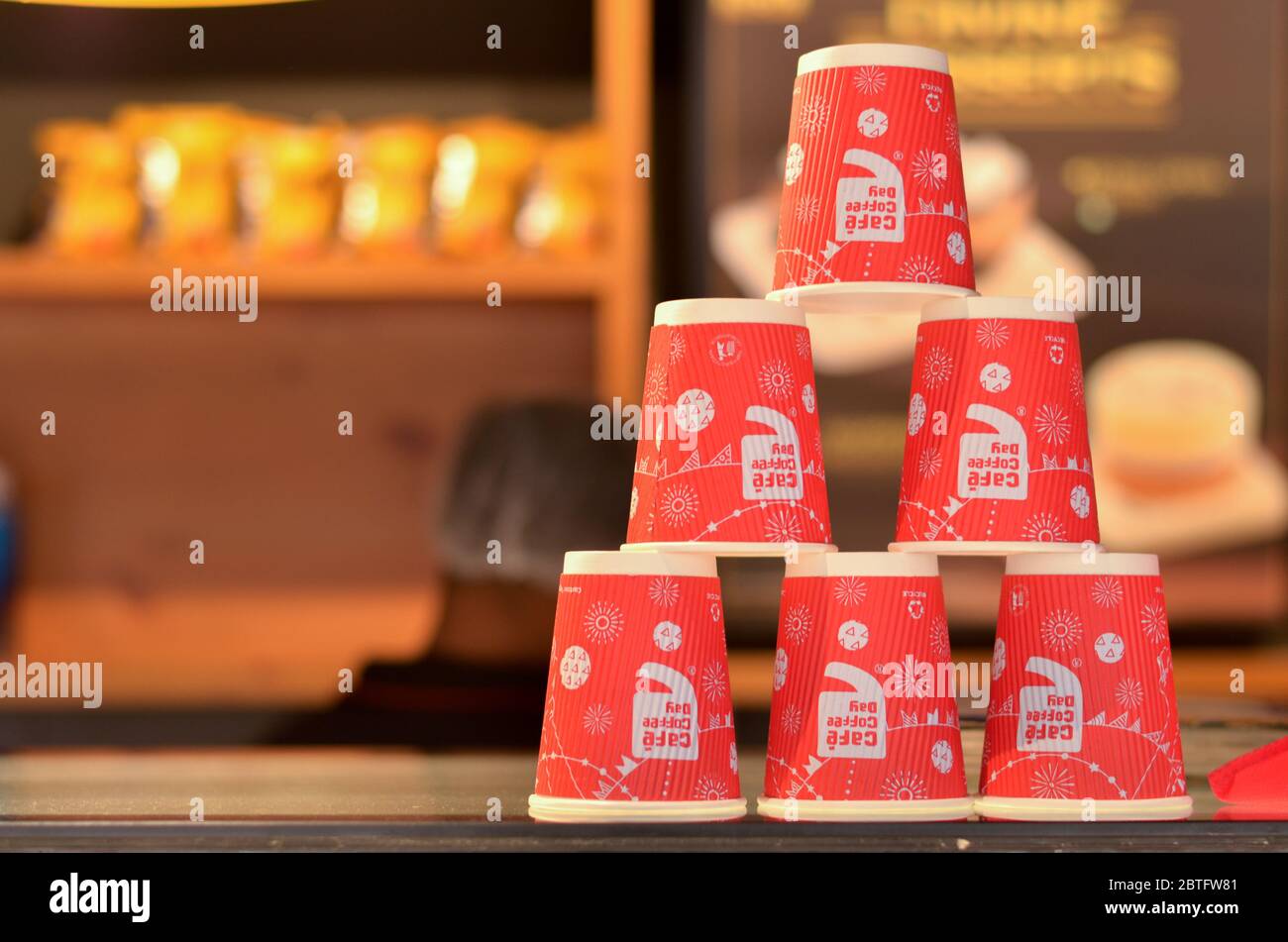 New Delhi, India, 2020. Red disposable cups with CCD (Cafe Coffee Day) logo stacked on top of each other making pyramids on the counter for display Stock Photo
