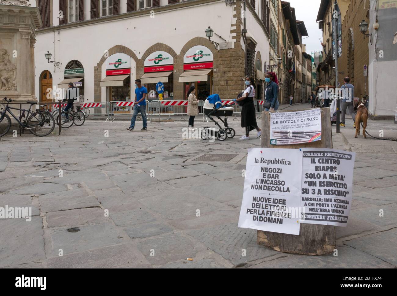 Florence, Italy - 2020, May 18: People walking on the city street during covid-19 lockdown. Headlines in the foreground. Stock Photo
