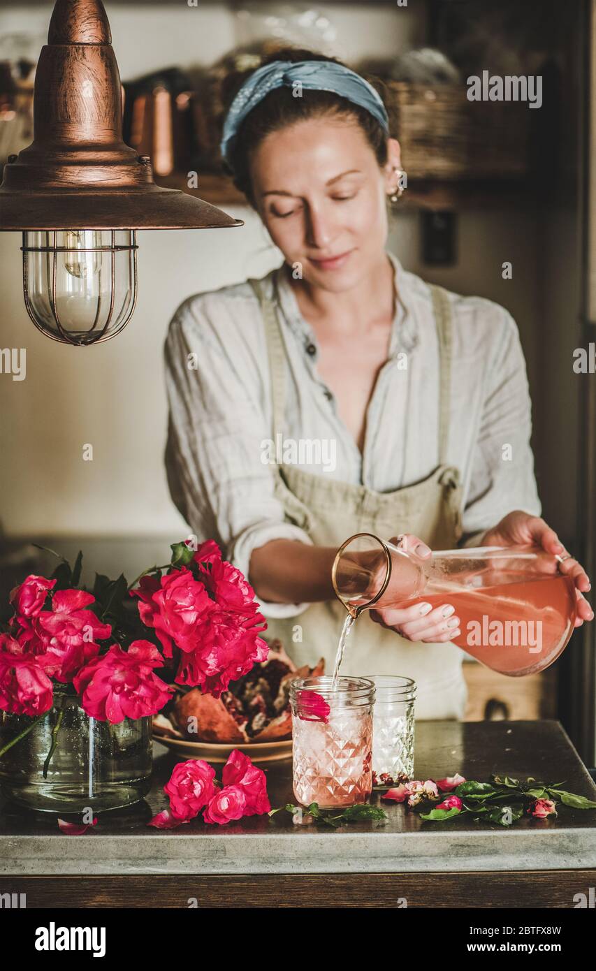 Young woman pouring rose lemonade to glasses in kitchen Stock Photo - Alamy