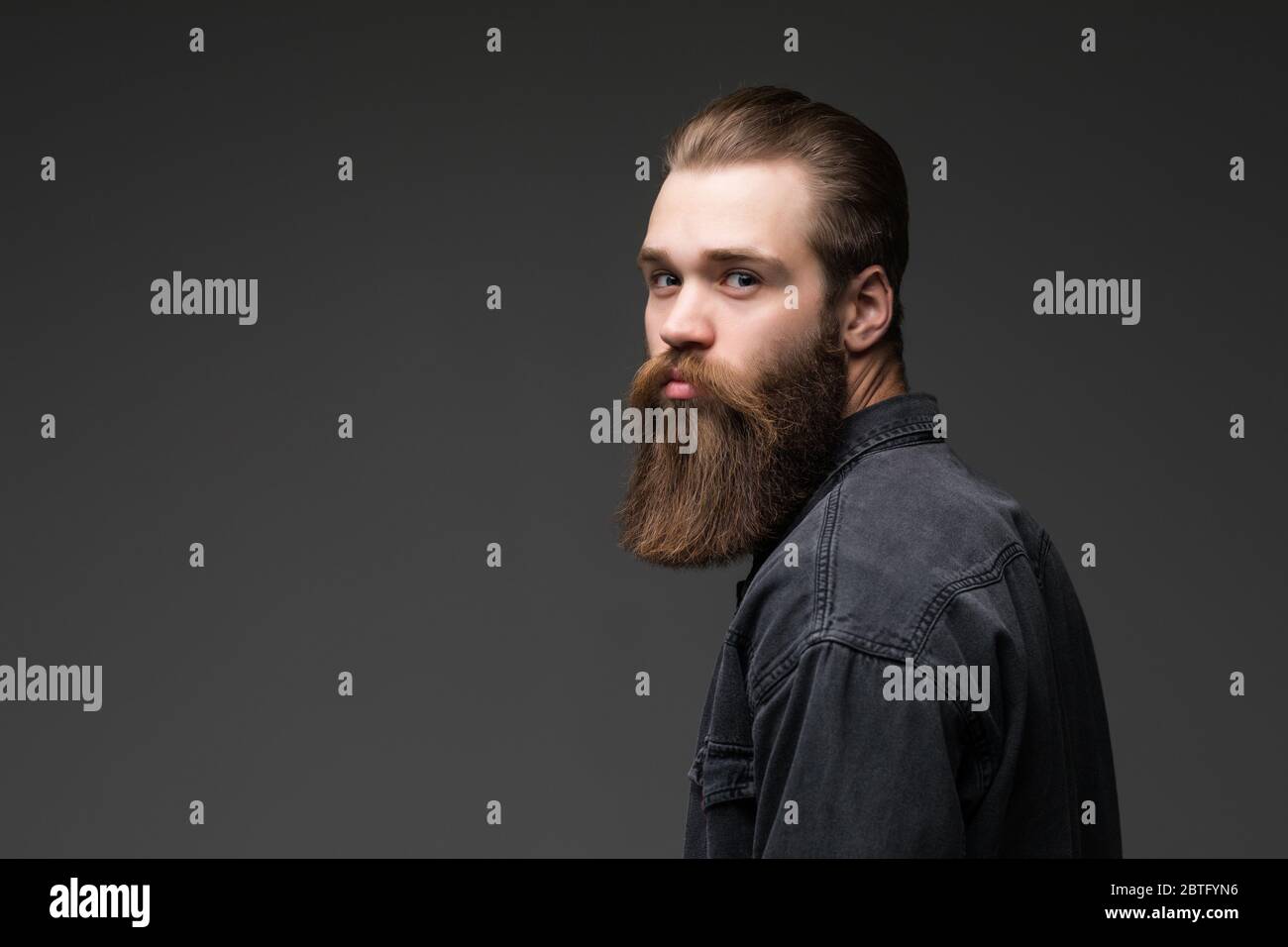 Handsome bearded young man isolated on gray background Stock Photo