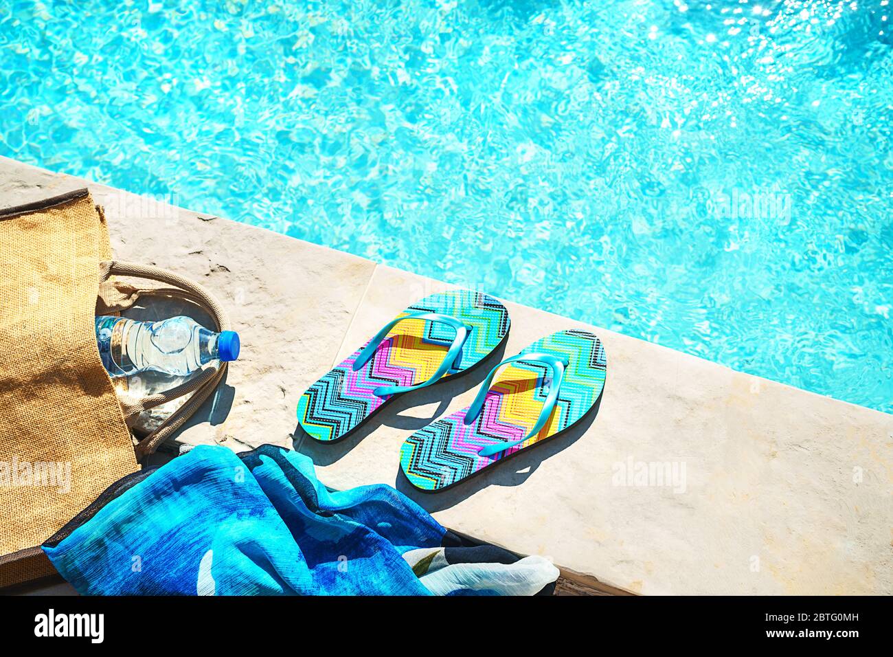 Swimming pool and straw hat, colorful flip flops, wicker bag, straw hat ...