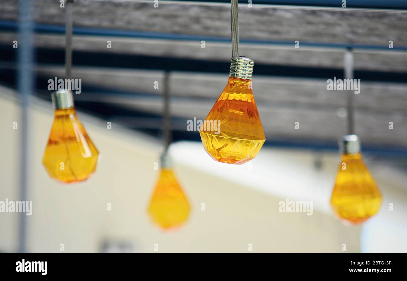 Closeup of hanging orange party bulbs on terrace roof. Stock Photo