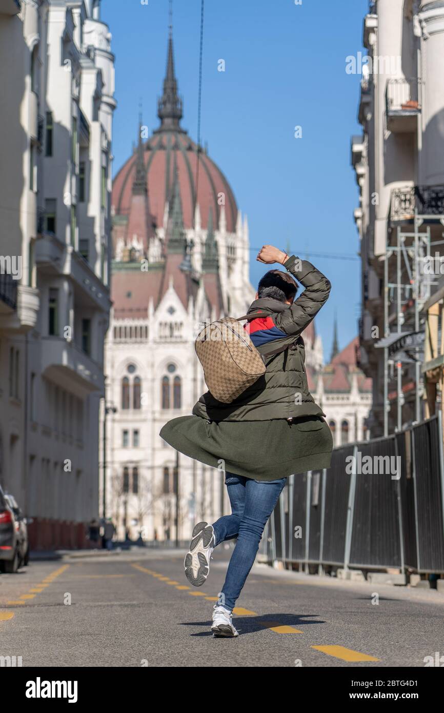 Feb 8, 2020 - Budapest, Hungary: Tourist dance on Akademia street with view of Hungarian Parliament Stock Photo