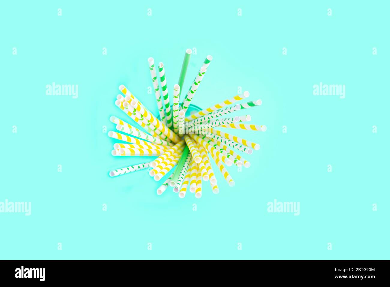 Paper Cocktail tubes in a grass on the blue background. Copy space. minimalism Stock Photo