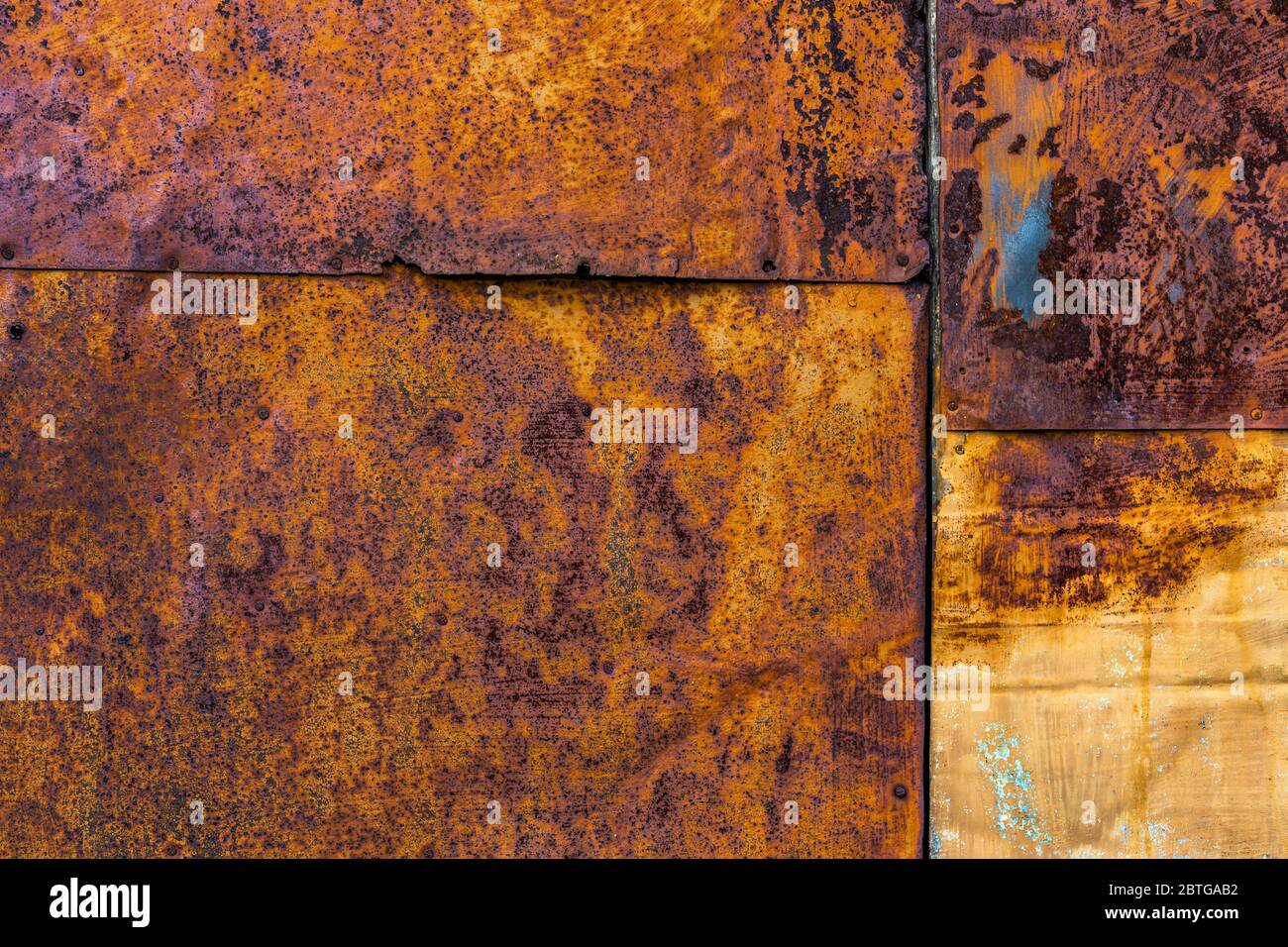 Rusted flat composite nailed metal sheets surface background and texture. Stock Photo