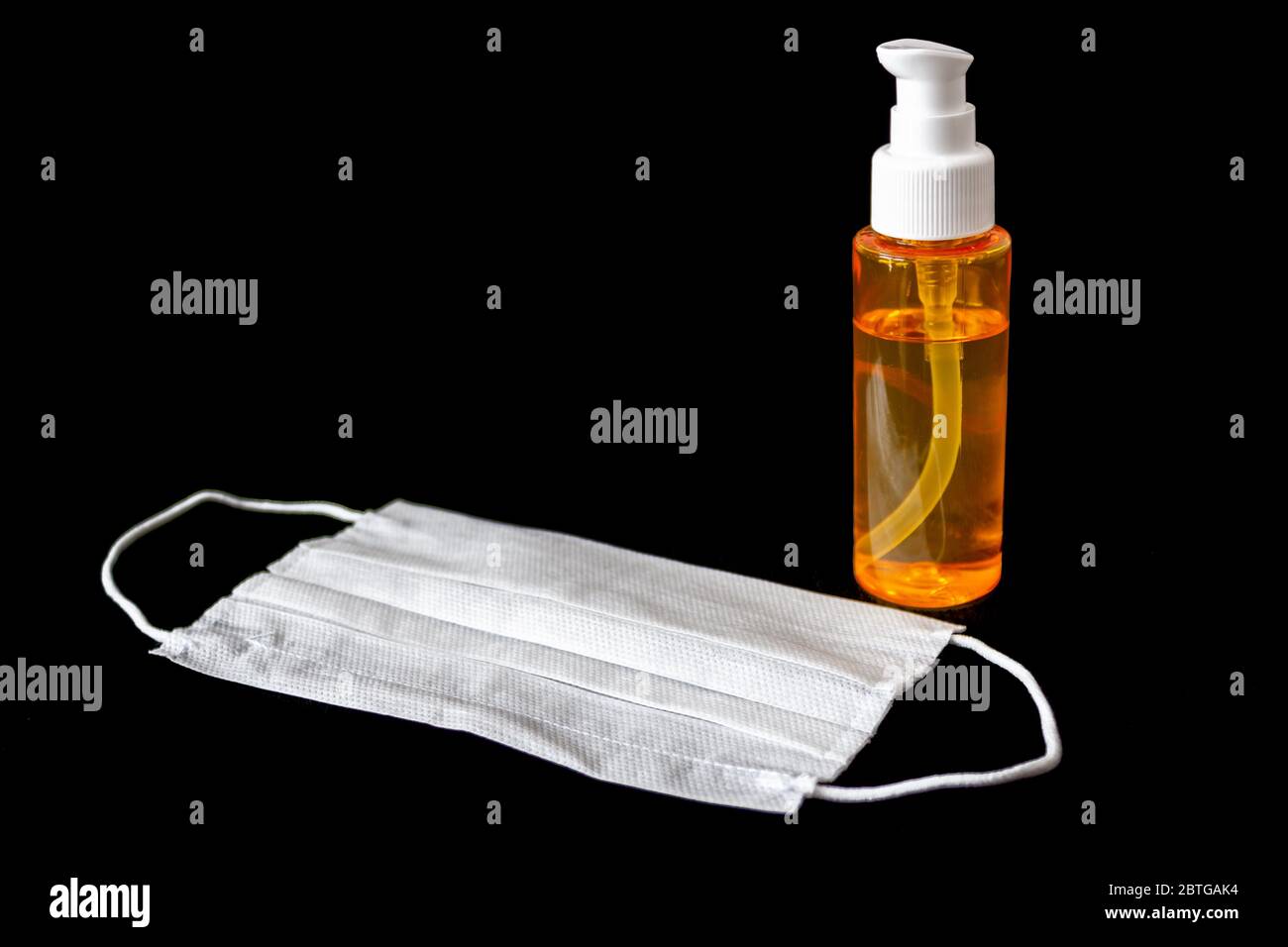 Protective mask and hand disinfectant,sanitizer isolated black background. Protective material against epidemic disease ( covid-19 ) Coronavirus Stock Photo