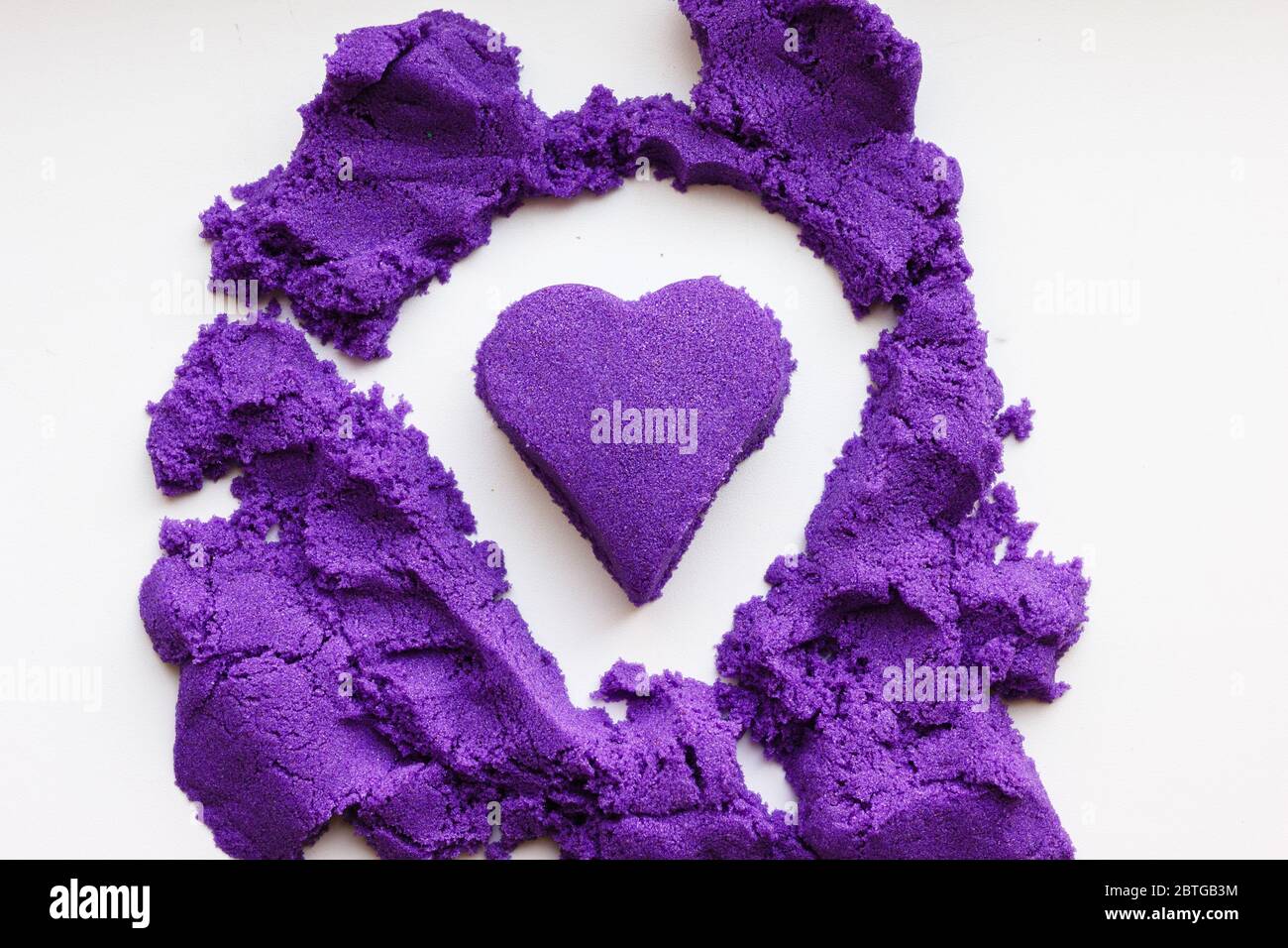 purple kinetic sand in the shape of a heart. Love concept. Sensory  development of children Stock Photo - Alamy