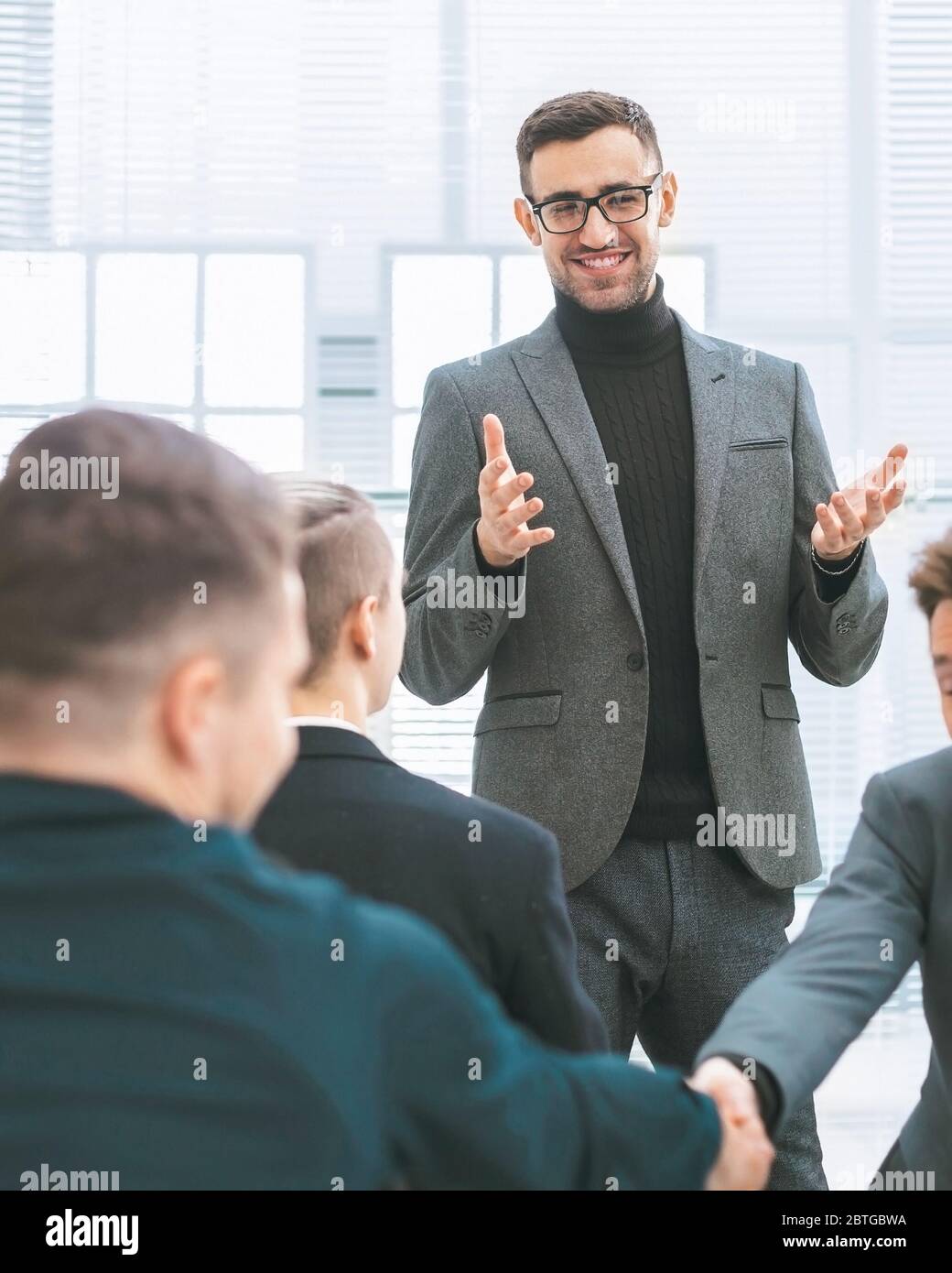 smiling employees shaking hands during a working meeting Stock Photo