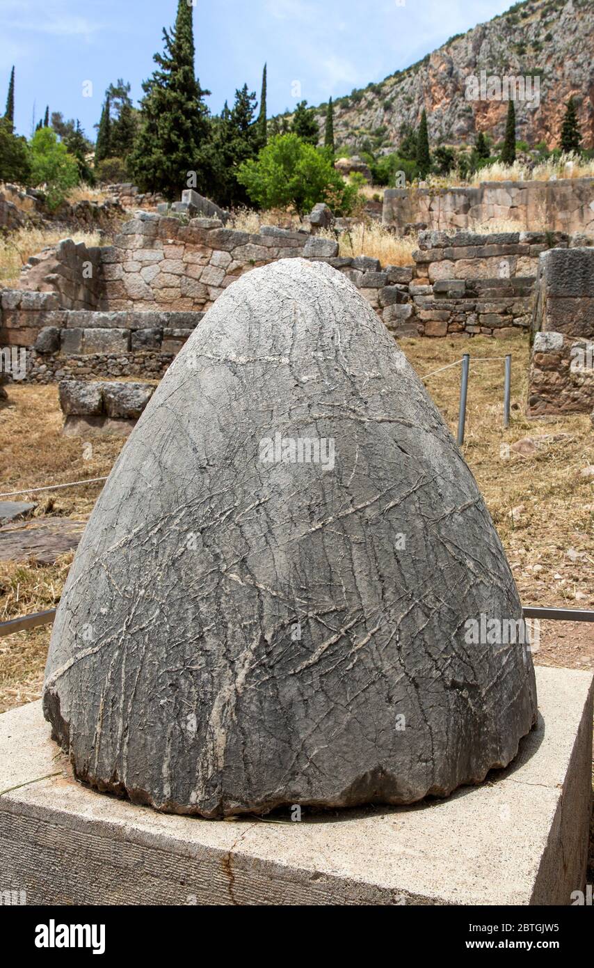 The stone Omphalos, symbol of the center of the earth outside Delphi Archaeological Museum in Delphi Greece.  The Omphalus stone was believed to allow Stock Photo