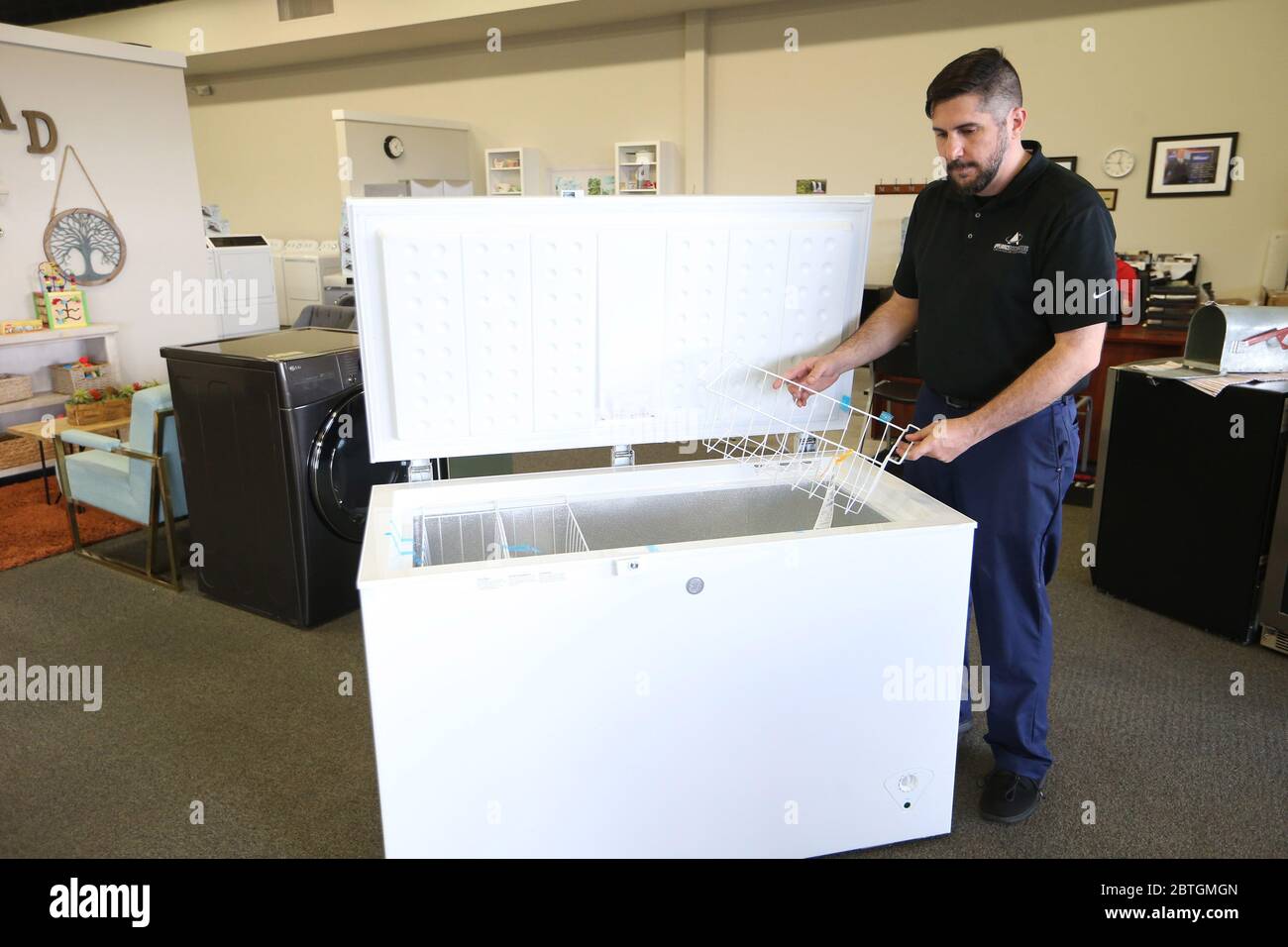 St. Louis, United States. 25th May, 2020. Sales person Armando McVey examines a new freezer that has just arrived on the sales floor at The Appliance Discounters in St. Louis on May 25, 2020. As people purchase more food to freeze and reduce their trips to the store, due to COVID-19 concerns, there has been a double-digit increases in the number of freezers sold compared to the same time last year. Most deep freezers are either sold out or on back order for several months. Photo by Bill Greenblatt/UPI Credit: UPI/Alamy Live News Stock Photo