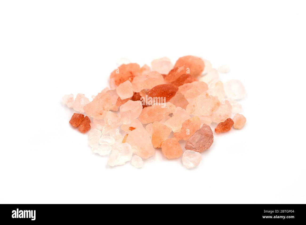 Pile of Himalayan pink salt salt from Punjab region, Pakistan heap on white isolated background in side view, close up macro concept. Himalayan pink r Stock Photo