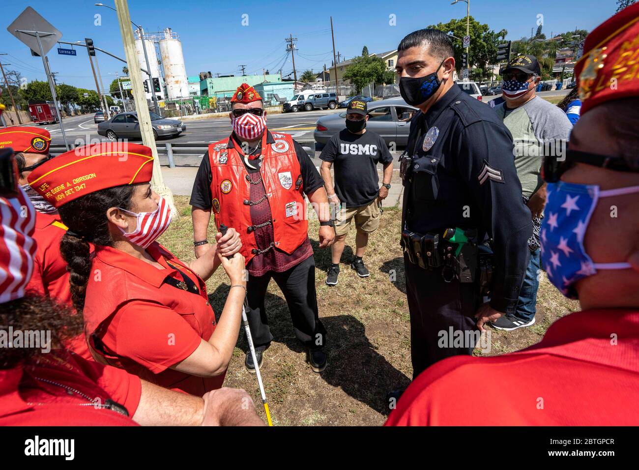Los Angeles, California, USA. 15th Mar, 2019. Veterans wearing face masks talk with an LAPD officer following a Memorial Day ceremony in the Boyle Heights neighbourhood of Los Angeles.The event took place at the Los Cinco Puntos/Five Points Memorial that honours Mexican American soldiers who died in the World War II, the Korean War, and the Vietnam War. Credit: Ronen Tivony/SOPA Images/ZUMA Wire/Alamy Live News Stock Photo