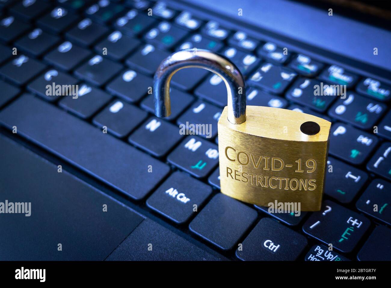 COVID-19 coronavirus lockdown restrictions ease concept illustrated by unlocked padlock on laptop. Stock Photo