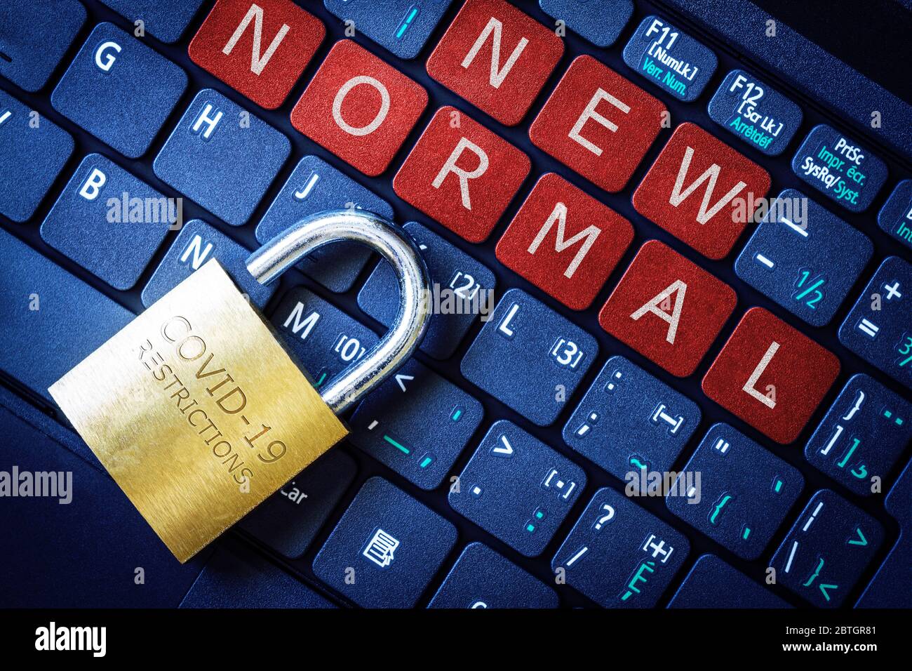 COVID-19 coronavirus lockdown restrictions ease concept illustrated by unlocked padlock with New Normal on laptop red alert keyboard buttons. Stock Photo