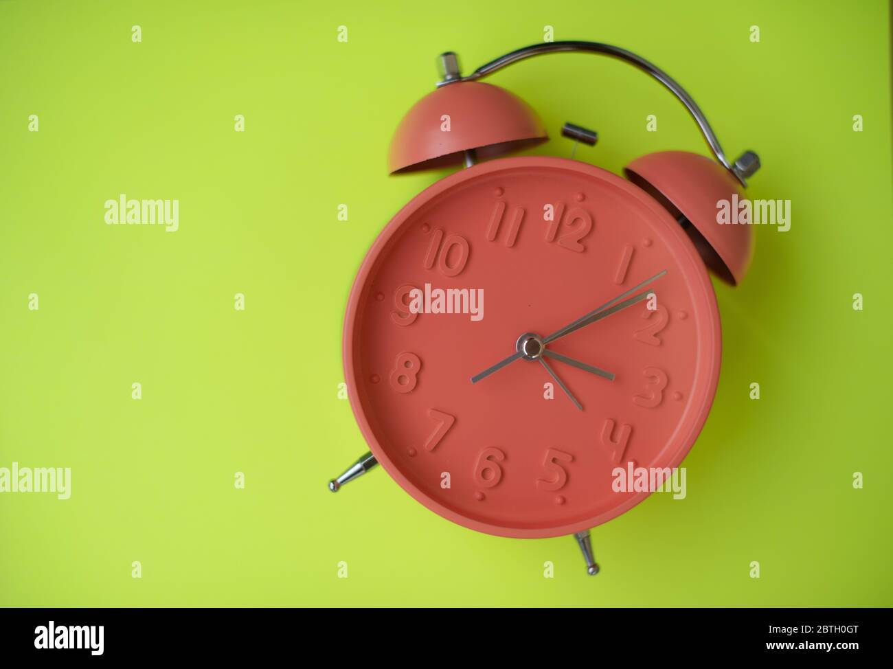 Colorful clock isolated against yellow background Stock Photo