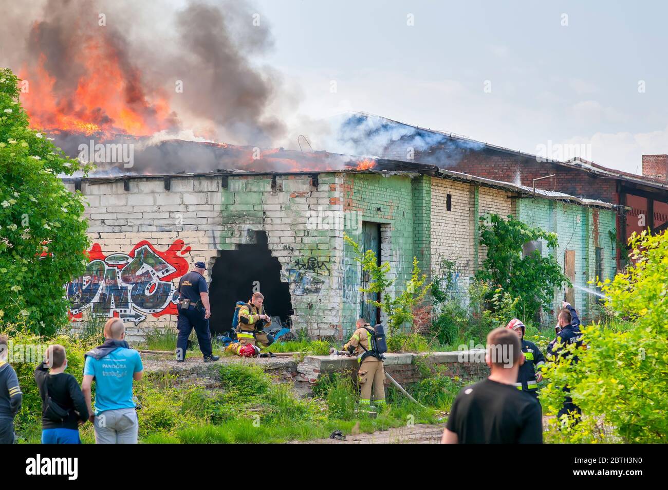 Wroclaw, Poland, May 2020. Firefighters, Fire brigade fighting fire in old abandoned building, Stock Photo