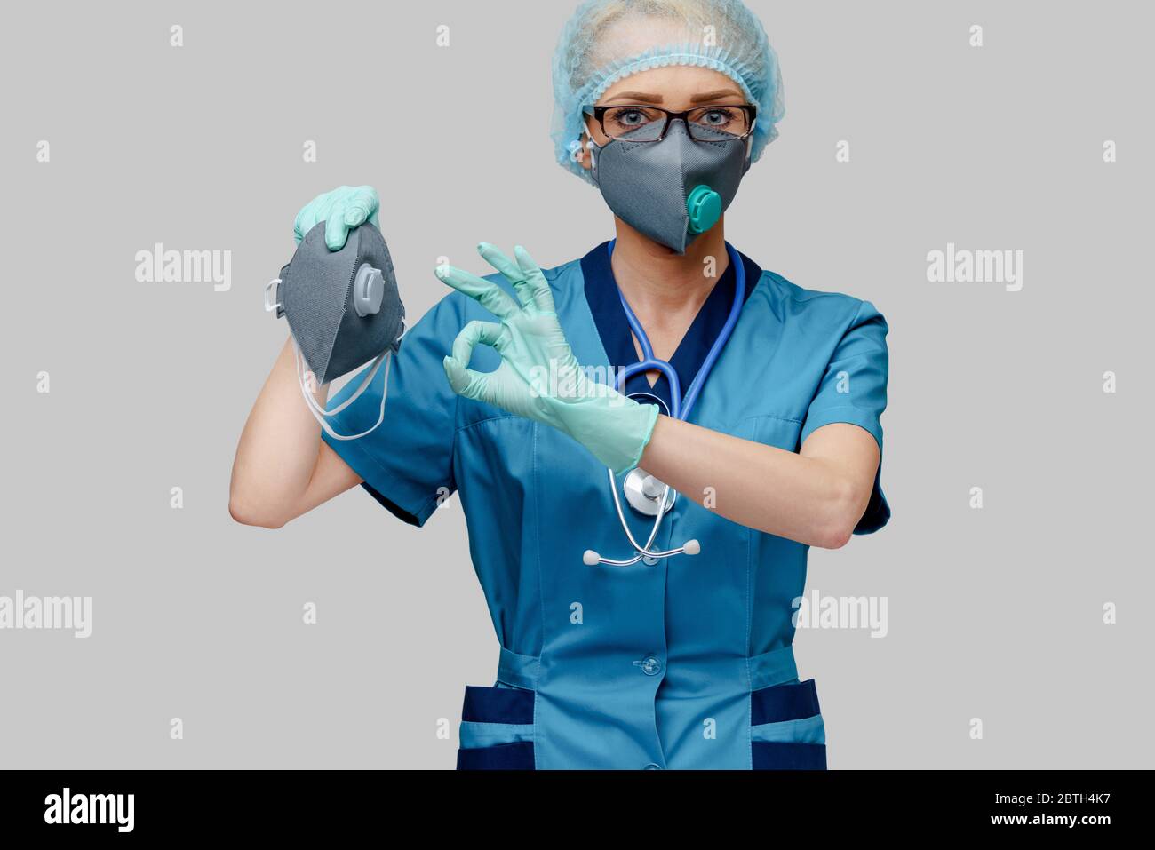female doctor with stethoscope wearing protective mask and latex gloves ...