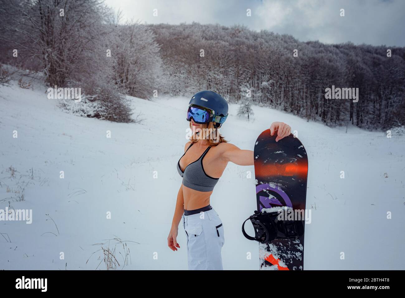 voelen klant kompas Female snowboarder hold snowboard and going to snowboarding. winter sport  activity, forest snow outdoors lifestyle. Girl wearing a short top and ski  w Stock Photo - Alamy