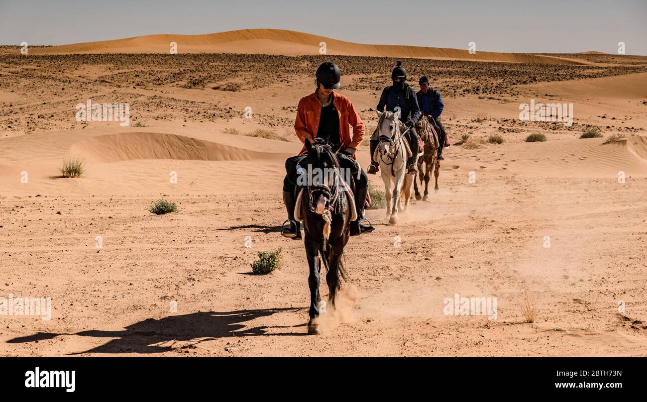 Three horseman travelling through the desert Stock Photo