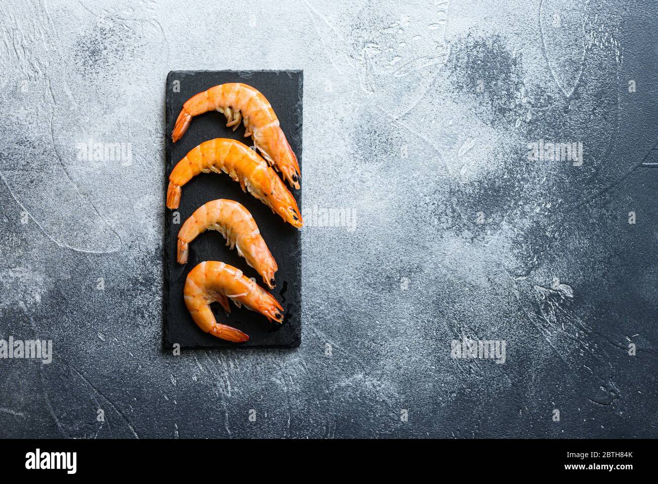 Raw ingredients Shrimp prawns on a stone cutting board over textured ...