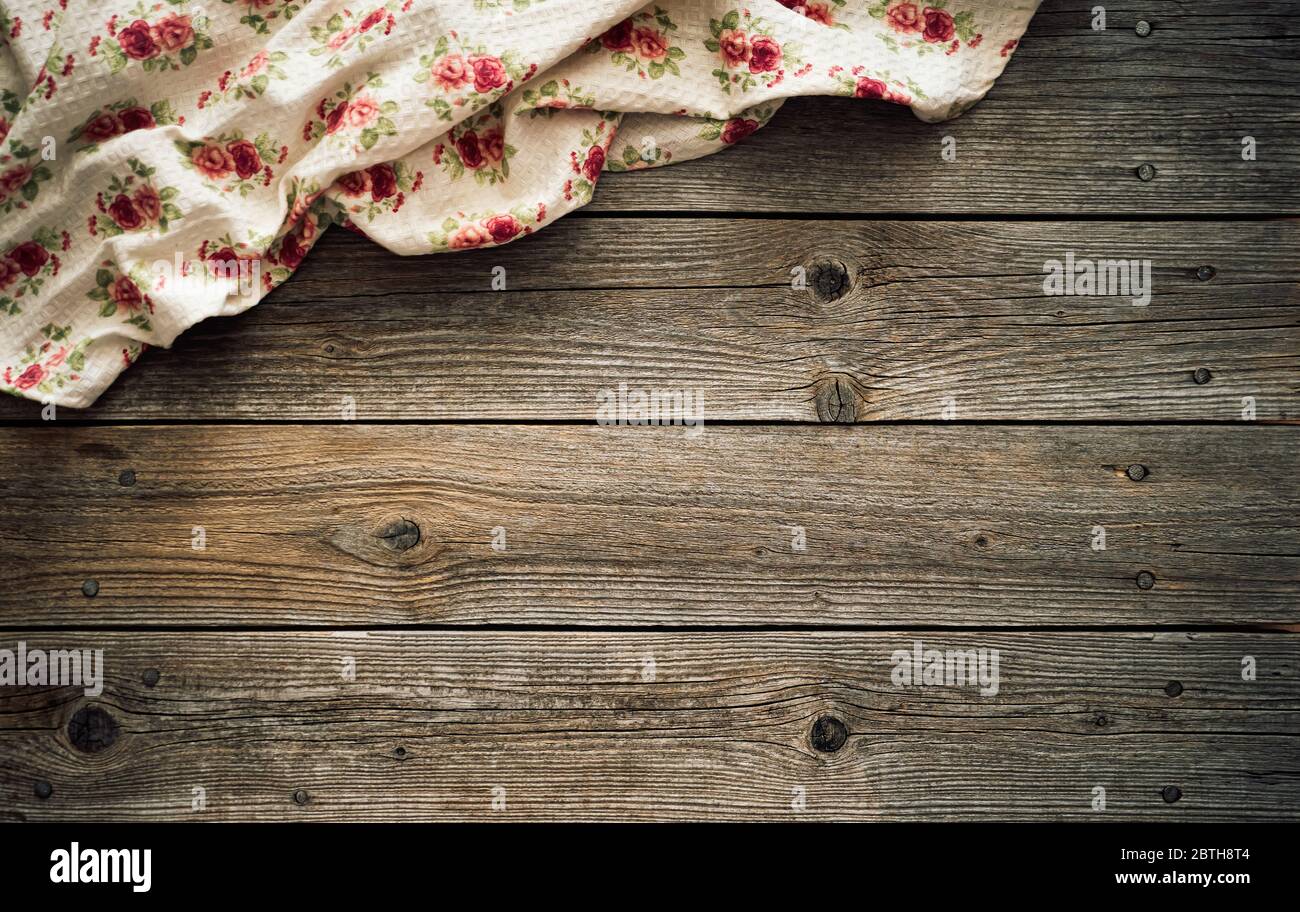 Vintage kitchen tablecloth on rustic wooden table made of rough old wood planks. Textured background with copy space for your advertising text message Stock Photo