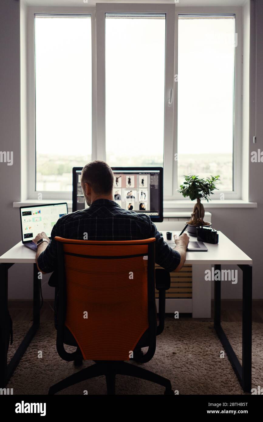 Freelancer man working remotely from home. Young male working on his computer Stock Photo