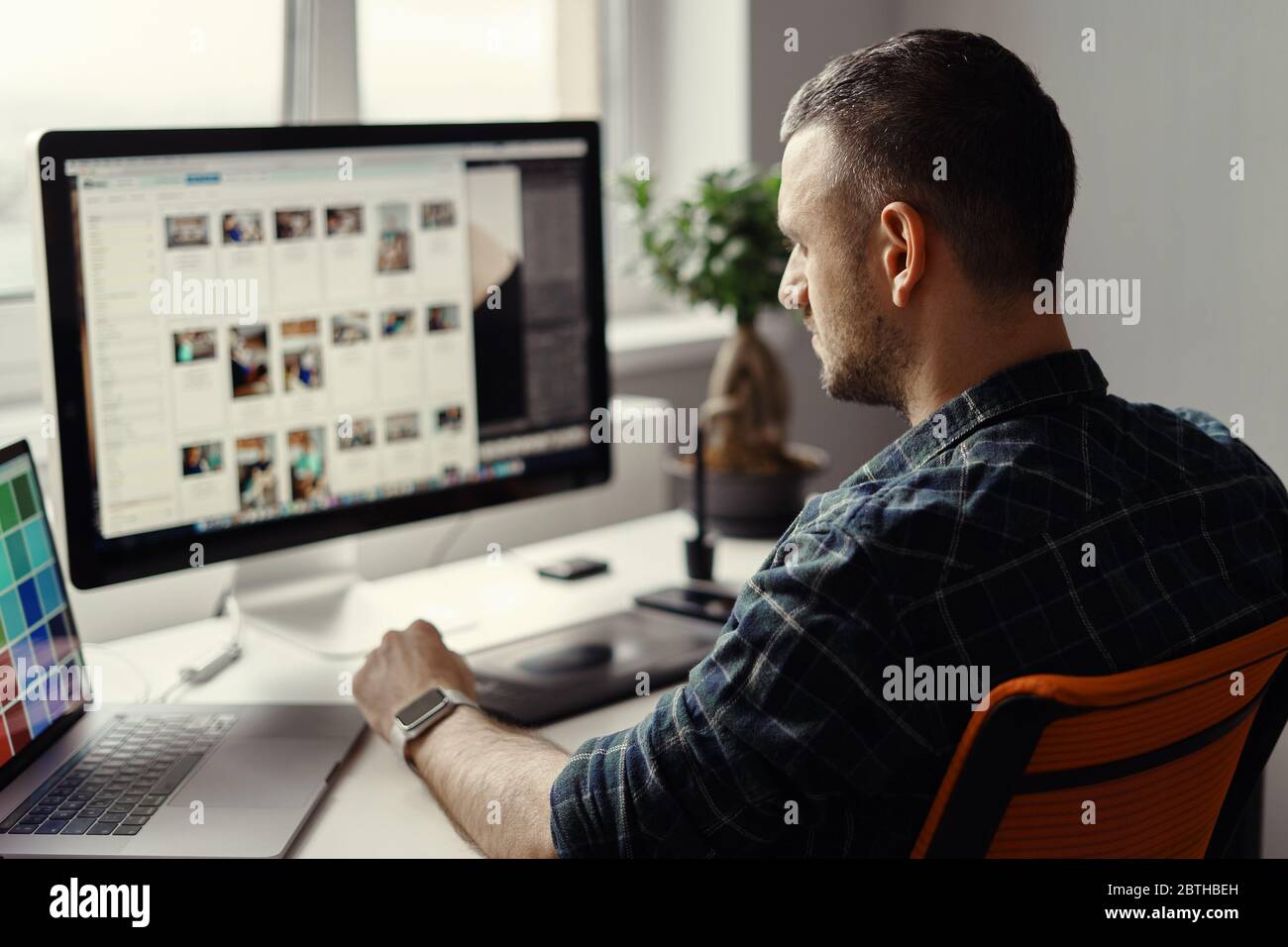 Handsome freelancer man working remotely from home. Young male working on his computer Stock Photo