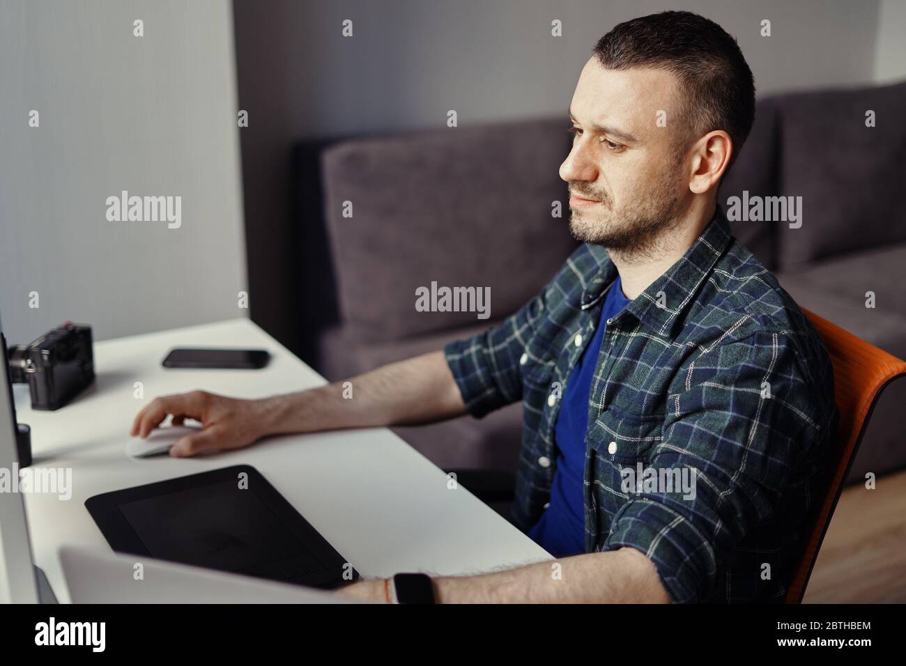 Handsome freelancer man working remotely from home. Young male working on his computer Stock Photo