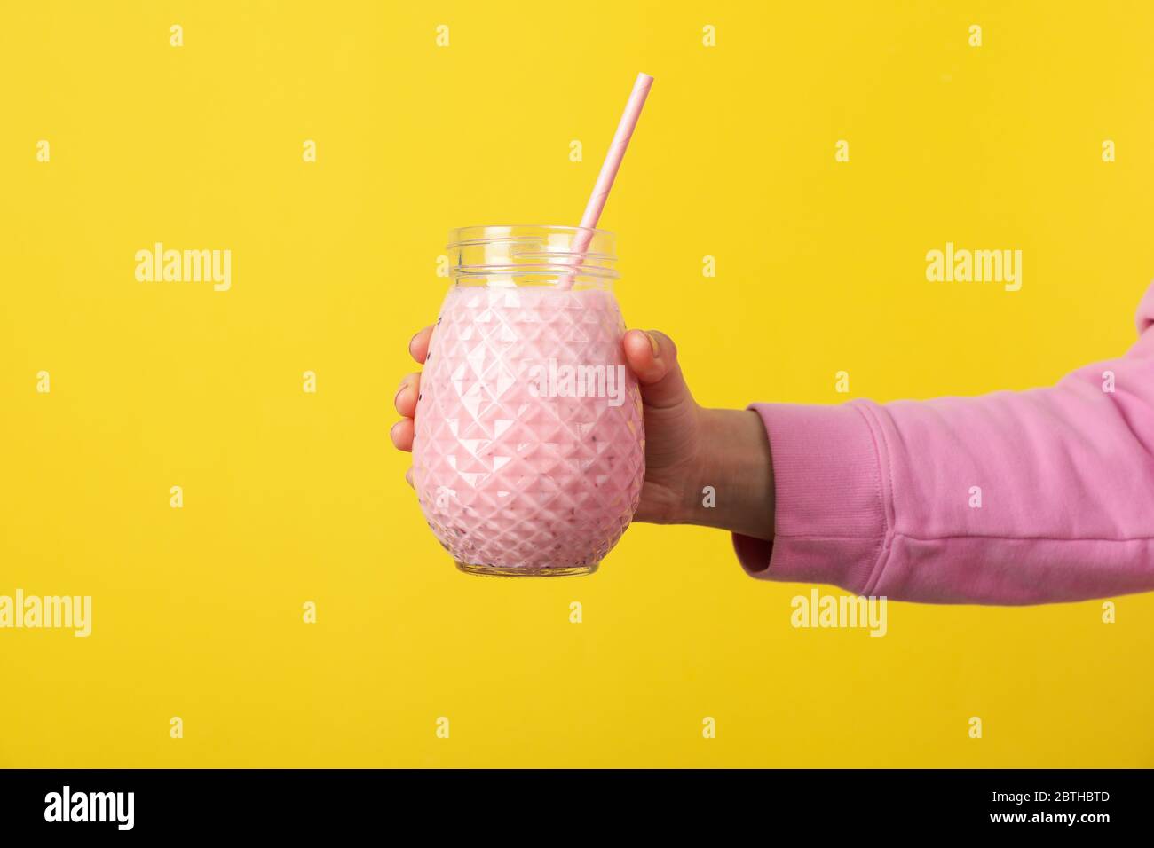 Download Woman Holds Glass Of Strawberry Milkshake On Yellow Background Stock Photo Alamy PSD Mockup Templates