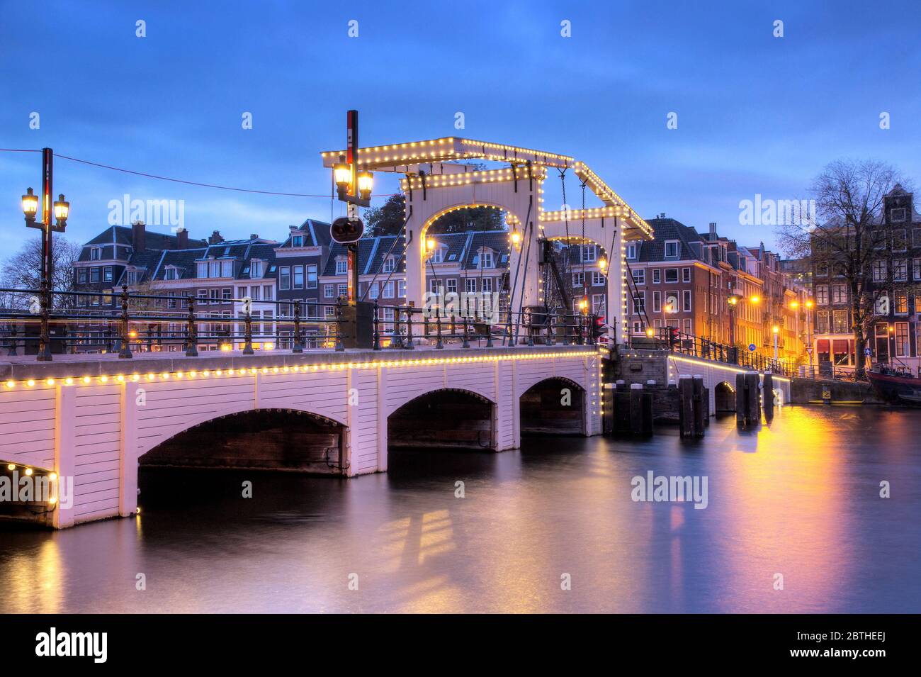 Amstel river cityscape with the famous skinny bridge in Amsterdam, the Netherlands, early in the morning in winter Stock Photo