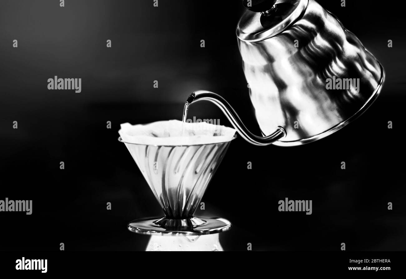 Drip coffee making pour over coffee with hot water being poured from a