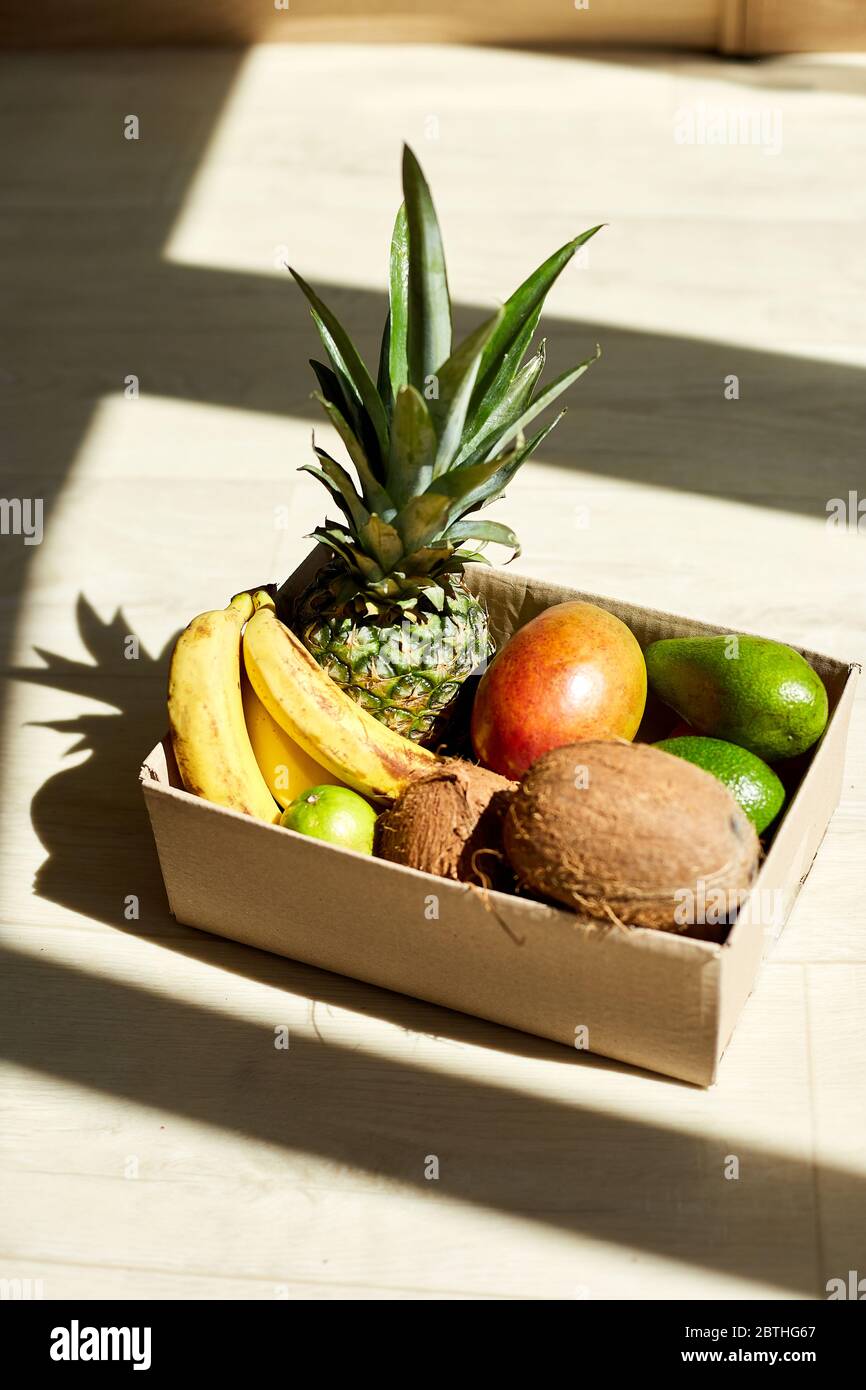 Assortment of organic exotic fruits in box, sunlight. Stock Photo