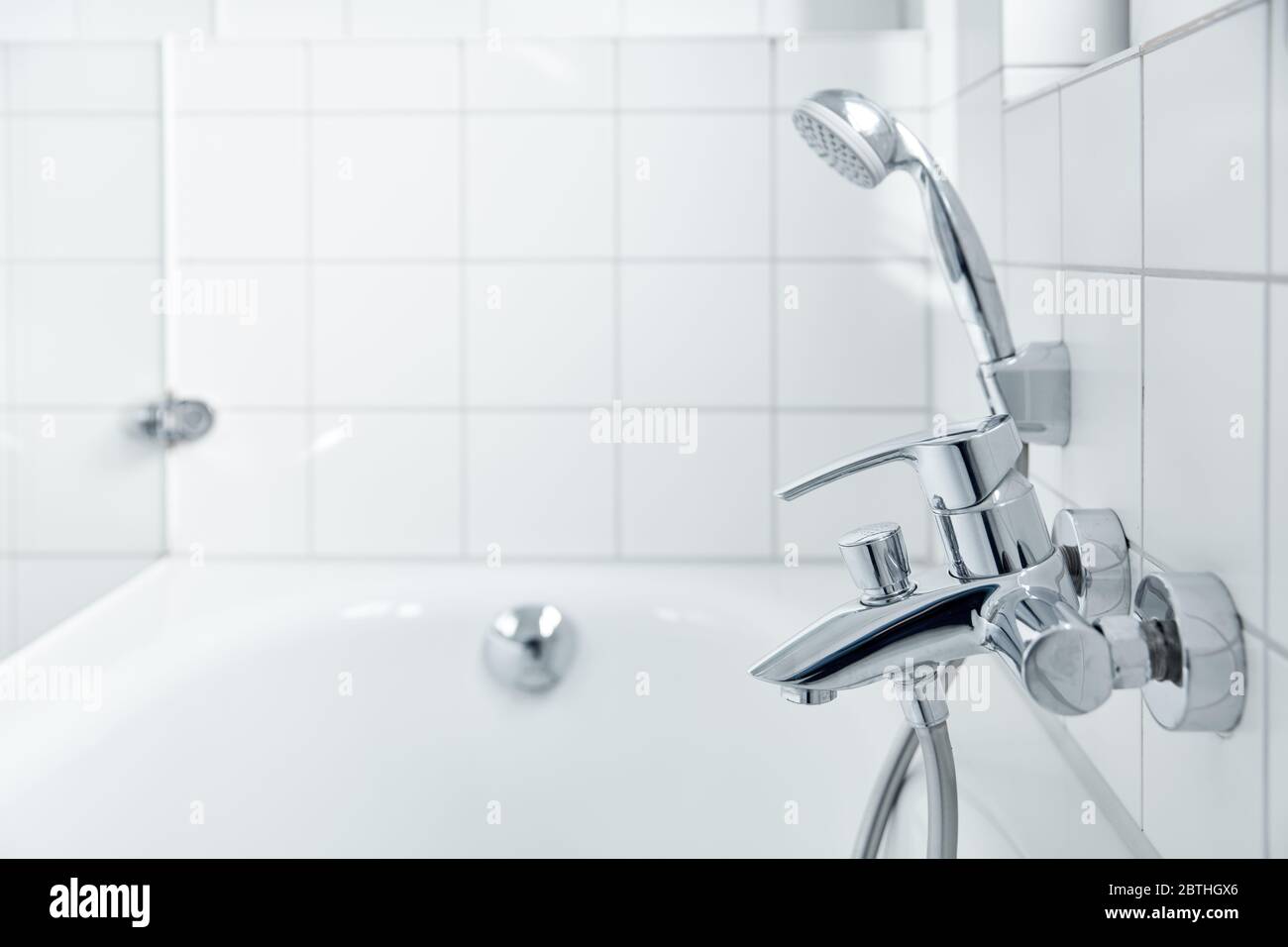 Bright white bathtub with shower head in modern bathroom Stock Photo Alamy