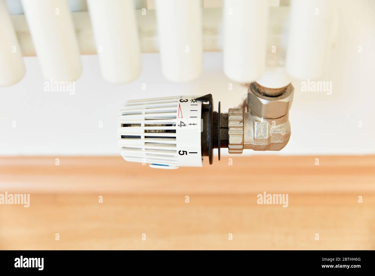 Temperature regulator on three on radiators of a heater on wall Stock Photo