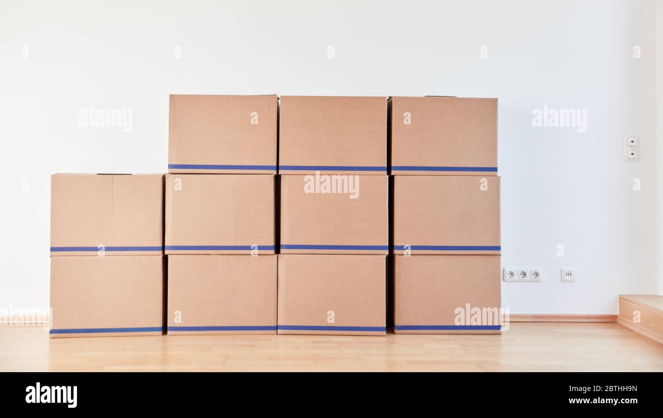 Many moving boxes on wall after an office move with moving company or freight forwarder Stock Photo