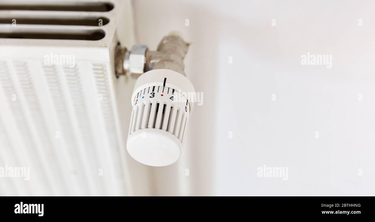 Modern thermostat on old heating as heating costs and energy consumption concept Stock Photo