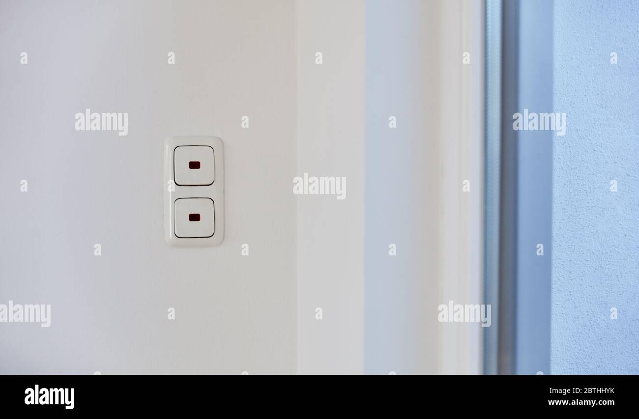 Two light switches one above the other on a wall in an apartment Stock Photo